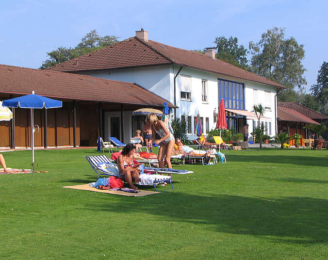 Liegewiese mit Badegästen, im Hintergrund Eingangsgebäude