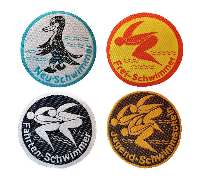 vier textile Abzeichen mit Pinguin und drei mit jeweils ein, zwei und drei stilisierten Schwimmern